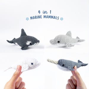 May include: Four crocheted marine mammal toys: a gray and white orca, a gray dolphin, a white beluga whale, and a gray narwhal with a cream-colored tusk.  The toys are arranged in a grid pattern on a white background.  The text "4 in 1 MARINE MAMMALS" is above the toys.