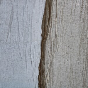 May include: Close-up of two pieces of fabric, one white and one brown, with a textured, wrinkled surface.
