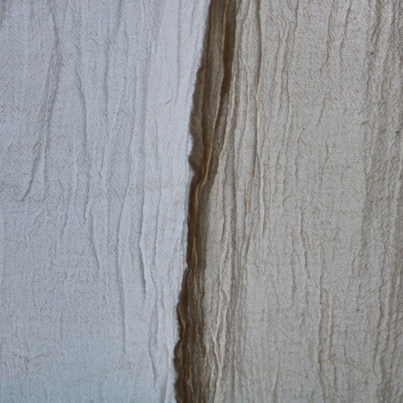 May include: Close-up of two pieces of fabric, one white and one brown, with a textured, wrinkled surface.