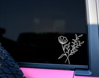 May include: A white outline of a flower and leaves on a black background. The sticker is on the back window of a pink car.