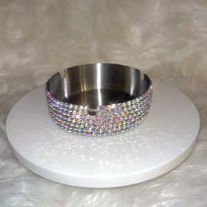 May include: A silver ashtray with a decorative iridescent crystal trim.