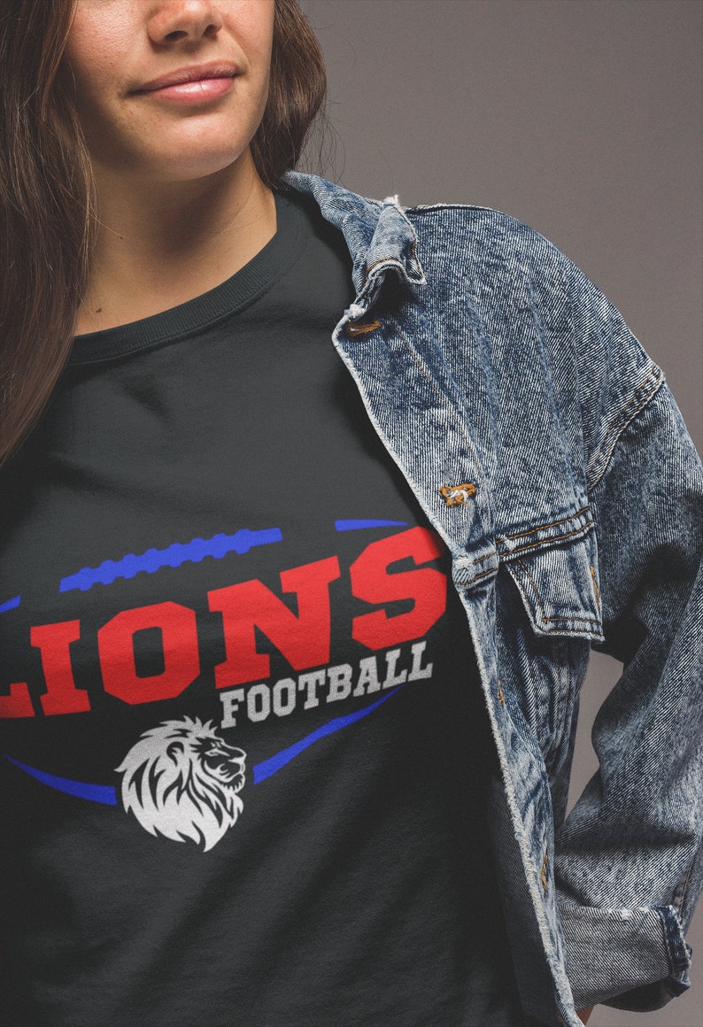 May include: A black t-shirt with a blue and red graphic of a football with the word "LIONS" in red and "FOOTBALL" in white.
