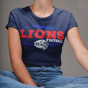 May include: A navy blue t-shirt with a white lion graphic and the text "Lions Football" in red and blue.