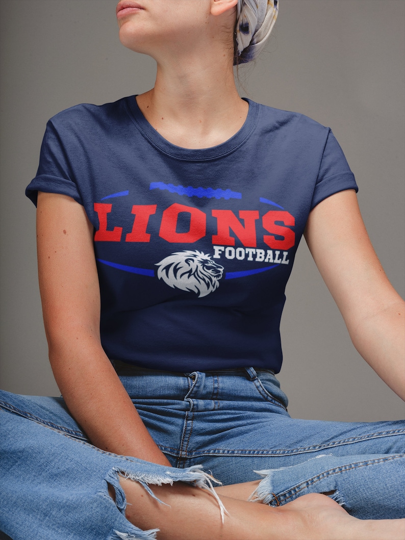 May include: A navy blue t-shirt with a white lion graphic and the text "Lions Football" in red and blue.