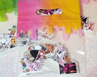May include: Clear plastic bags filled with assorted stickers. The bags have a pink and yellow gradient design with a drip effect. The stickers feature various illustrations and text, including a bunny, a witch, and the words "JESUS" and "CUT TODAY".