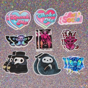 May include: A set of 10 colorful stickers featuring various designs, including hearts with text, a butterfly, a skull, a devil card, and a creature with horns. The stickers are on a sparkly background.