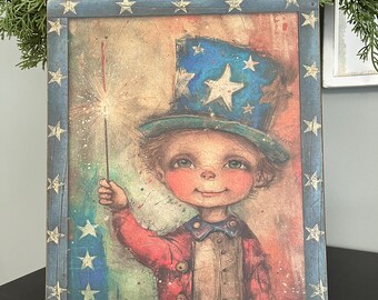 May include: A wooden sign with a patriotic theme featuring a cartoon child wearing a blue and white hat with stars and holding a sparkler. The sign has a blue background with white stars and the text "Sweet land of liberty".
