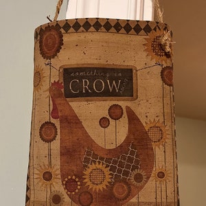 May include: A brown burlap tote bag with a brown and white chicken design and the text "something to CROW about".