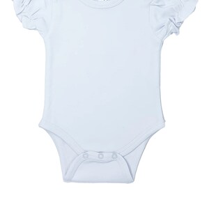 May include: A light blue baby bodysuit with short, ruffled sleeves. The bodysuit has a round neckline and snap closures at the bottom and shoulder. The label reads "AJ Blanks 3-6M".