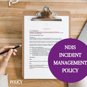 May include: A clipboard with a document titled "Incident Management Policy" on a wooden desk. The document outlines guidelines for incident management, including definitions, applicability, and who the policy applies to. The document is partially obscured by a purple circle with the text "NDIS Incident Management Policy".