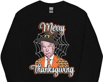 May include: Black long-sleeved t-shirt featuring a graphic of a man wearing a witch's hat and the text "Merry Thanksgiving".