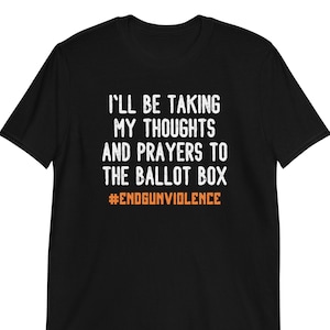 May include: Black t-shirt with white text that reads "I'll be taking my thoughts and prayers to the ballot box #endgunviolence".