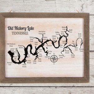 May include: A framed map of Old Hickory Lake in Tennessee. The map shows the lake's shape and various points of interest, including creeks, coves, and a marina.