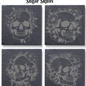 May include: Set of four black slate coasters with a white design of sugar skulls surrounded by flowers. The coasters are square and have a rustic look.
