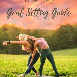 Può includere: Due donne eseguono posizioni yoga su un tappetino in un campo erboso. Indossano abbigliamento sportivo. Il testo "Namaste Soulful Goal Setting Guide" è nella parte superiore dell'immagine.
