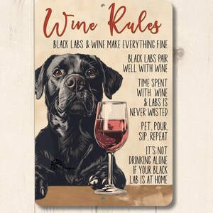 May include: A metal sign with a black Labrador Retriever and a glass of red wine. The sign reads "Wine Rules" and includes the text "Black Labs & Wine Make Everything Fine", "Black Labs Pair Well With Wine", "Time Spent With Wine & Labs Is Never Wasted", "Pet. Pour. Sip. Repeat", and "It's Not Drinking Alone If Your Black Lab Is At Home".