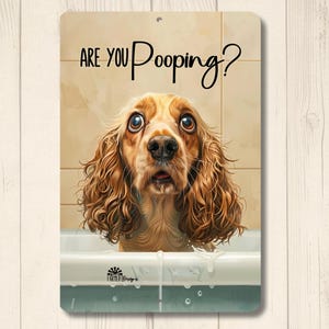 May include: A metal sign with a distressed finish features a Cocker Spaniel in a bathtub with the text "ARE YOU Pooping?" in black script. The dog has large, expressive eyes and a surprised expression. The sign has a Farm Life Designs logo.