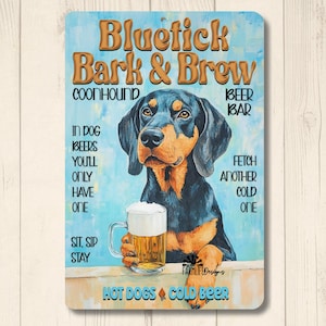 May include: A metal sign with a Bluetick Coonhound dog holding a beer mug. The sign reads "Bluetick Bark & Brew" with text about beer and hot dogs. The background is light blue.