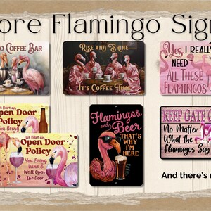 May include: A collection of eight metal signs featuring pink flamingos with various humorous sayings. The signs have a rustic woodgrain background and feature phrases like "Flamingo Coffee Bar", "Rise and Shine It's Coffee Time", "Yes I Really Do Need All These Flamingos", "Flamingos and Beer That's Why I'm Here", "We Have an Open Door Policy You Bring", "Keep Gate Closed No Matter What the Flamingos Say".