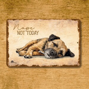 May include: A rectangular metal sign with a distressed, vintage look. The sign features a sleeping dog illustration in shades of brown and black, with the words "Nope NOT TODAY" in a handwritten font. The background has a parchment-like appearance.