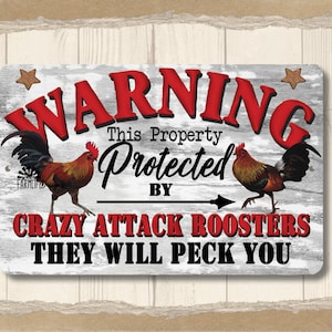 May include: A white metal sign with a distressed woodgrain texture. The sign reads "WARNING This Property Protected By Crazy Attack Roosters They Will Peck You". Two red roosters are pictured on either side of the text.