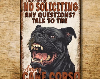 May include: A rectangular metal sign with a distressed finish. The sign features a detailed illustration of an angry black Cane Corso dog with bared teeth. Text reads "Absolutely NO SOLICITING ANY QUESTIONS? TALK TO THE ANGRY CANE CORSO."