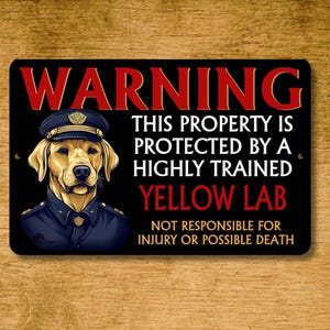 May include: Black metal sign with the word "WARNING" in red. It features a yellow Labrador wearing a police uniform and the text: "THIS PROPERTY IS PROTECTED BY A HIGHLY TRAINED YELLOW LAB. NOT RESPONSIBLE FOR INJURY OR POSSIBLE DEATH."