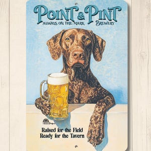 May include: Metal sign featuring a brown dog holding a beer mug. The sign reads "Point & Pint Brewery" with the text "Always on the Mark." Below the dog, the sign says "Raised for the Field Ready for the Tavern."