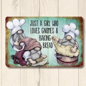 May include: A metal sign with a turquoise background featuring three gnomes baking bread. The sign reads "Just a girl who loves gnomes & baking bread".