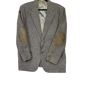 May include: A gray blazer with suede elbow patches. The jacket has a two-button closure and a light-colored lining. The blazer is a classic style, suitable for various occasions.