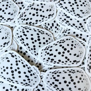 May include: A stack of white and black polka dot stickers with the text "@Chaybees" on each sticker.