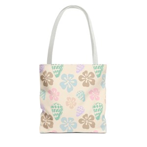 May include: A cream-colored tote bag featuring a repeating pattern of light blue, tan, and pink flowers interspersed with mint green and lavender seashells. The bag has two white fabric handles attached to the top, providing a simple structure.