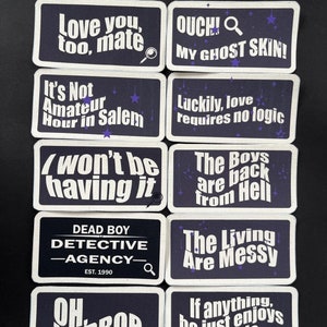 May include: A collection of rectangular patches with white text on a dark blue background. The patches feature phrases like "Love you, too, mate" and "Dead Boy Detective Agency." Some include small illustrations.