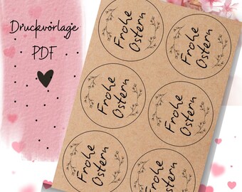 Puede incluir: Seis pegatinas circulares de papel marrón con el texto "Frohe Ostern" en letras negras con una corona de flores alrededor del texto.
