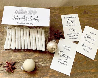 May include: An Advent calendar with 24 sayings, packaged in a clear bag. The top of the package has the words "Adventskalender" and "24 schöne Sprüche". Several small cards with German text and a silver ornament are also visible.