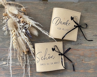 May include: Two small brown paper booklets tied with black ribbon. The top booklet says "Danke für alles!" and the bottom booklet says "Schön dass du da warst."