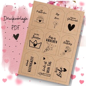 May include: Printable gift tags with birthday themes. The tags feature black and white illustrations of a cake, balloons, a crown, a party horn, a bouquet of flowers, a candle, and a heart. The text on the tags includes "Dein Pustekuchen", "Hipp Hurra", "Herzlichen Glückwunsch", "Lass Dich Feiern", "Lass es Krachen", "Happy Birthday", "Eine Kleinigkeit", "Heute ist Dein Tag", and "Alles Liebe".