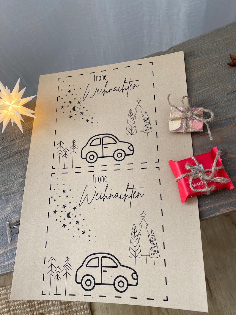 May include: Kraft paper Christmas gift tags with black line art of cars, trees, and stars. The words "Frohe Weihnachten" are written in script. Two small wrapped gifts are on the right.
