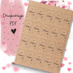 Może przedstawiać: Arkusz brązowego papieru z 20 drukowanymi etykietami prezentowymi. Każda etykieta ma serce i napis "VON Herzen" nadrukowany na niej.