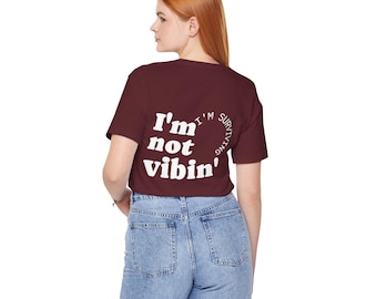 Camiseta con texto en la espalda que dice "No estoy vibrando, estoy sobreviviendo"