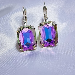 Puede incluir: Un par de pendientes de plata con piedras rectangulares iridiscentes de color morado y verde.