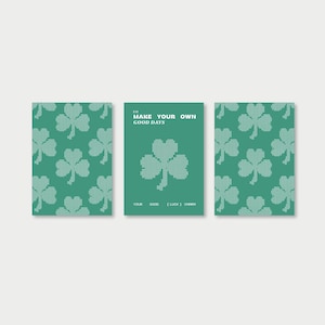 Könnte beinhalten: Drei grüne Karten mit weißen Kleemustern. Die mittlere Karte hat den Text "MAKE YOUR OWN GOOD DAYS" und ein Kleeblatt-Design. Der untere Teil der Karte lautet "YOUR GOOD [LUCK] CHARM".