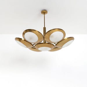 May include: A brass and white glass chandelier with a circular design. The chandelier has seven lights and a modern style.
