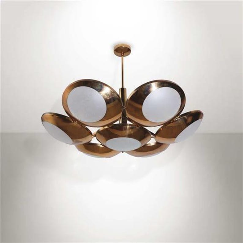 May include: A brass and white glass chandelier with six lights. The chandelier has a modern design with a circular shape.