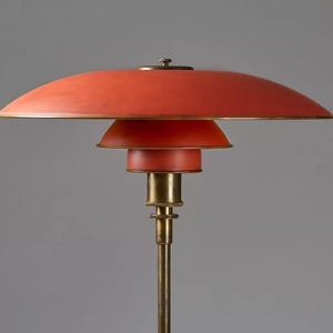 May include: A red and brass floor lamp with a three-tiered shade.