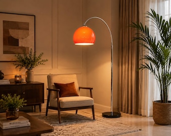 May include: A floor lamp with a bright orange dome-shaped shade, a slender chrome-finished curved metal arm, and a solid black circular base. The lamp emits a warm light, illuminating the area directly beneath the shade in a living space.