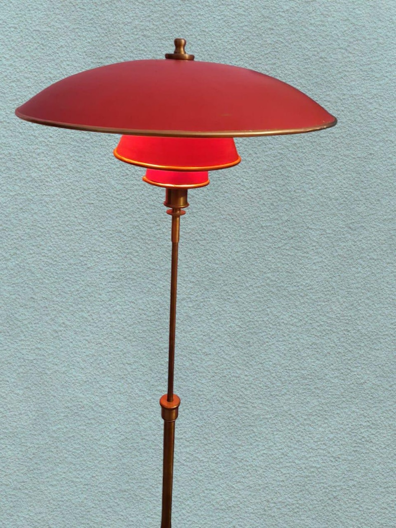 May include: A red and gold floor lamp with a large, round, red shade and three smaller, red shades. The lamp is on a tall, gold pole.