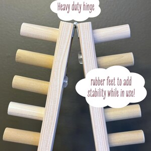 foldable chunky knit blanket loom 50” showing heavy duty hinge at folding point. rubber feet to add stability while in use.