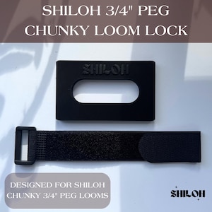 Könnte beinhalten: Schwarzes Webstuhl-Schloss- und Riemen-Set. Das Schloss ist rechteckig mit einem ovalen Ausschnitt und dem geprägten Wort "SHILOH". Der Riemen hat einen Klettverschluss. Der Text auf dem Bild lautet "SHILOH 3/4" PEG CHUNKY LOOM LOCK" und "DESIGNED FOR SHILOH CHUNKY 3/4" PEG LOOMS."