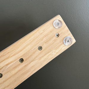 close up of underside of chunky knit blanket loom 50” showing screws and rubber feet